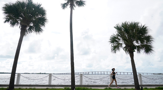 A jogger runs along a sea wall in Miami