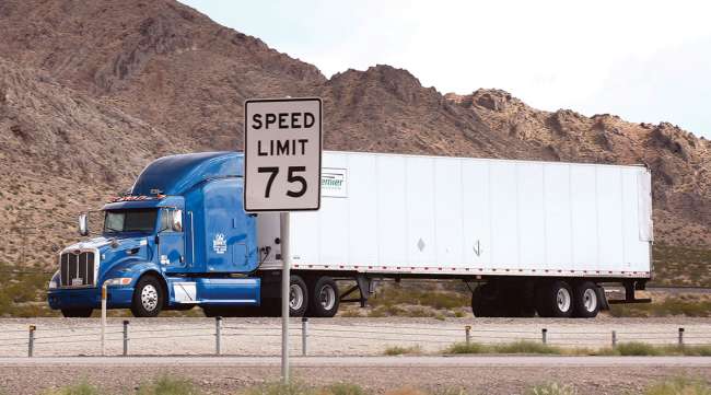 Truck on road with speed limit sign