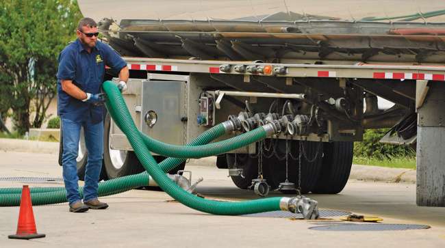 Truck driver connects fuel hoses