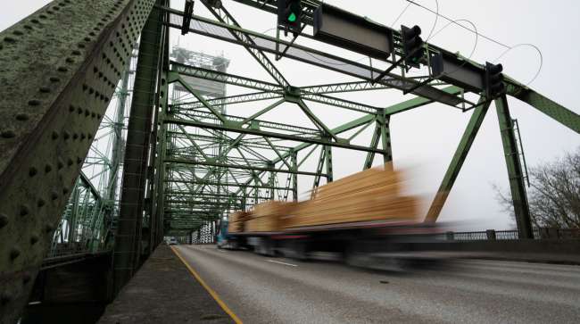 Blurred truck drives over steel bridge