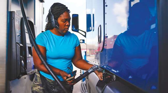 Female driver fueling truck