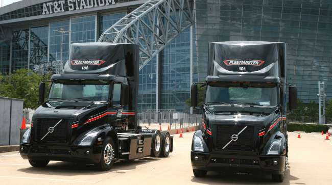 Fleetmaster's two Volvo VNR Electric trucks outside AT&T Stadium in Arlington, Texas