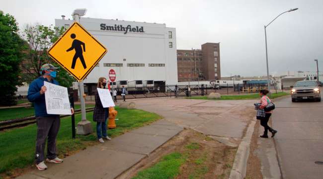 Residents cheered and held thank you signs to greet employees of a Smithfield pork processing plant as they began their shift on May 20 in Sioux Falls, S.D.