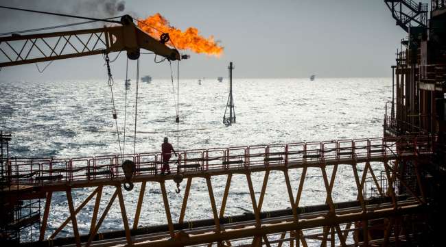 A gas flare burns from a pipe aboard an offshore oil platform in the Permian Gulf's Salman Oil Field in January 2017.