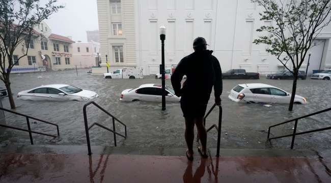A resident watches as flood waters move on the street in Pensacola, Fla.