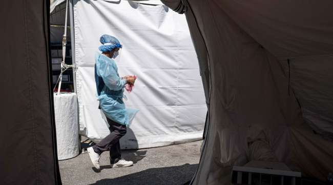 A public health worker walks to a tent to administer a COVID-19 test in California.