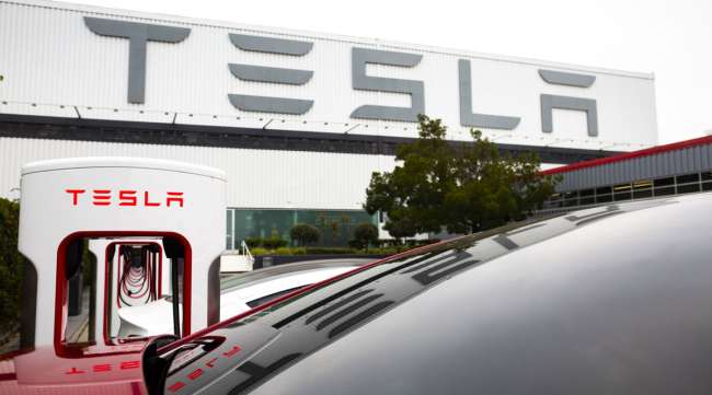Tesla vehicles charge at the Tesla Supercharger station in Fremont, Calif.
