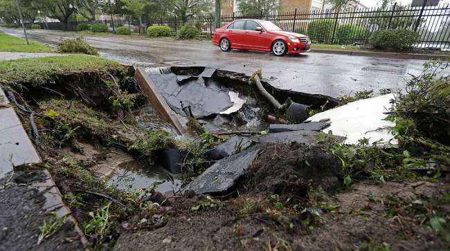 A car drives past a sinkhole in Wilmington, N.C.