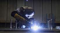 Worker welds bolts on to a sheet