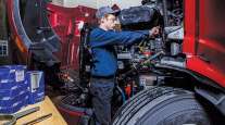 Technician working on truck engine