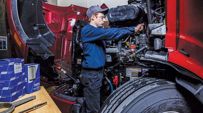 Technician working on truck engine