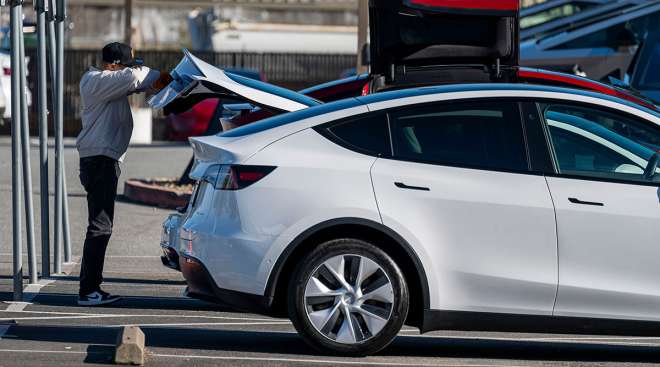 Customer looks inside trunk of a Tesla vehicle